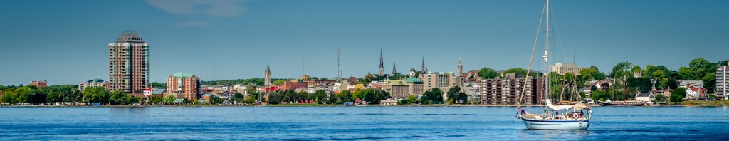 the town of Brockville, skyline looking at the town from the water a sail boat is in the distance