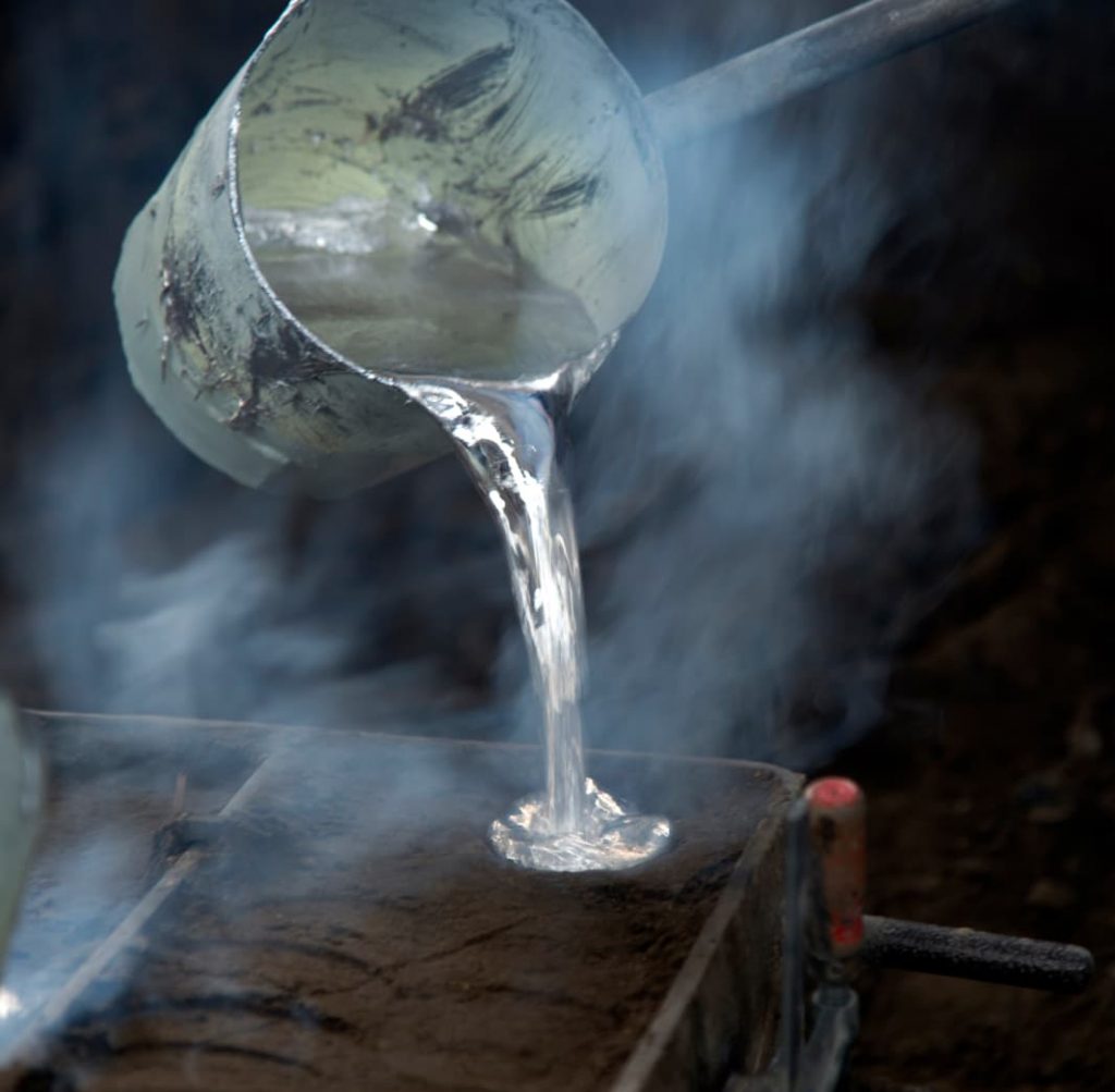 molten steel pouring into a mold block, very steamy hot heated metal.