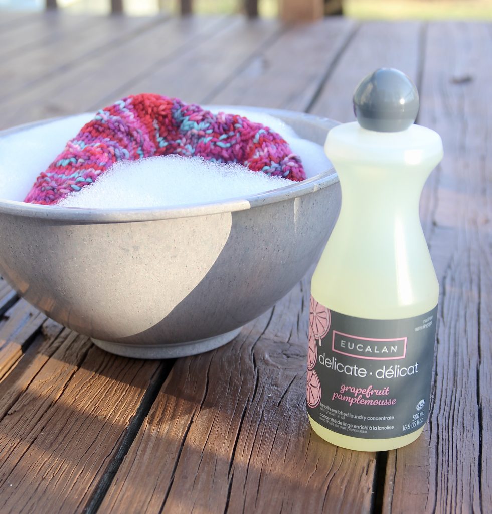 A bowl is filled with water and a bit of woolwash, and a cheerful hat is in the bowl soaking.